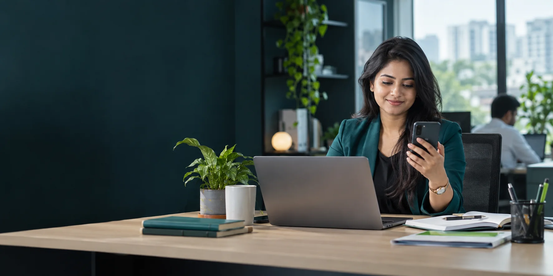Bangladeshi business professional reviewing SMS activity on a phone and laptop